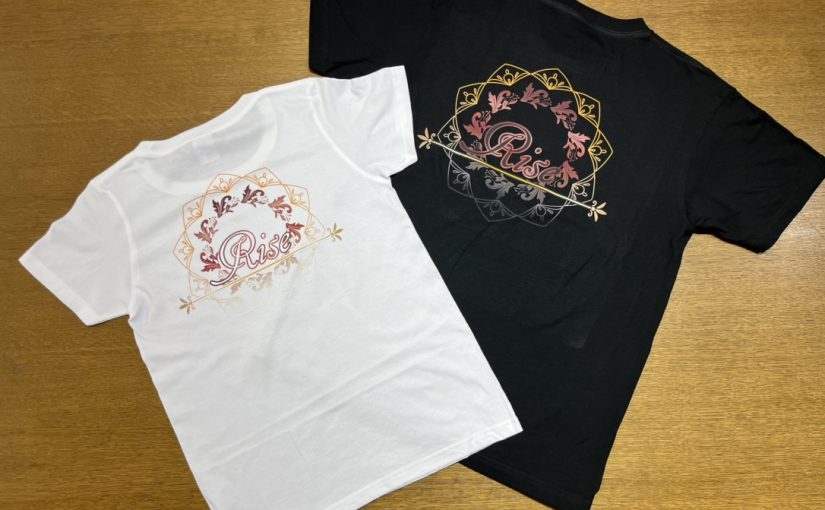 黒と白の生地のTシャツにRiseという文字を印刷しています